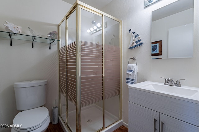 bathroom featuring toilet, vanity, and walk in shower