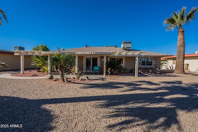 rear view of property with cooling unit, a pergola, and a patio area