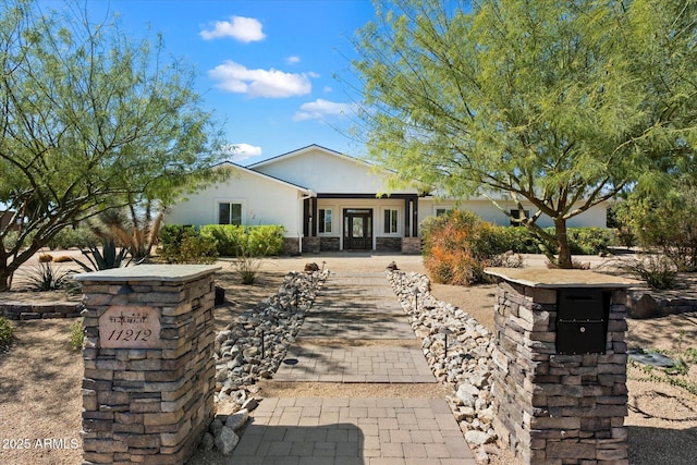 exterior space featuring stone siding and stucco siding