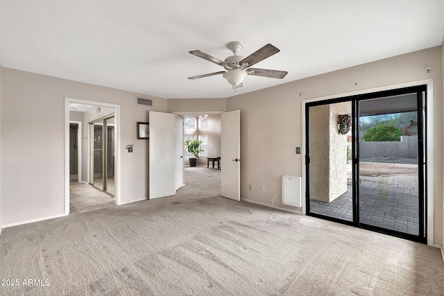 carpeted spare room with visible vents, baseboards, and a ceiling fan