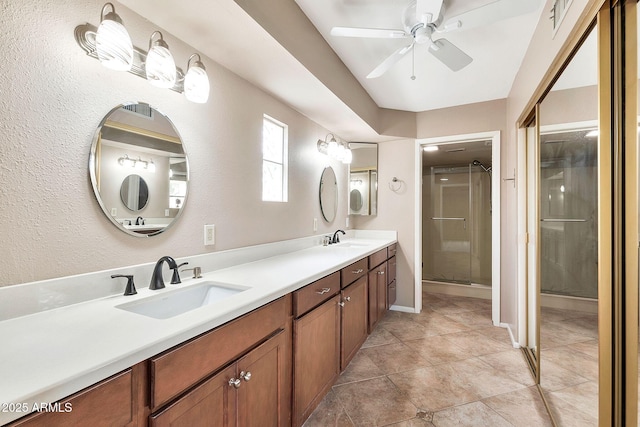 bathroom with double vanity, a stall shower, tile patterned floors, and a sink