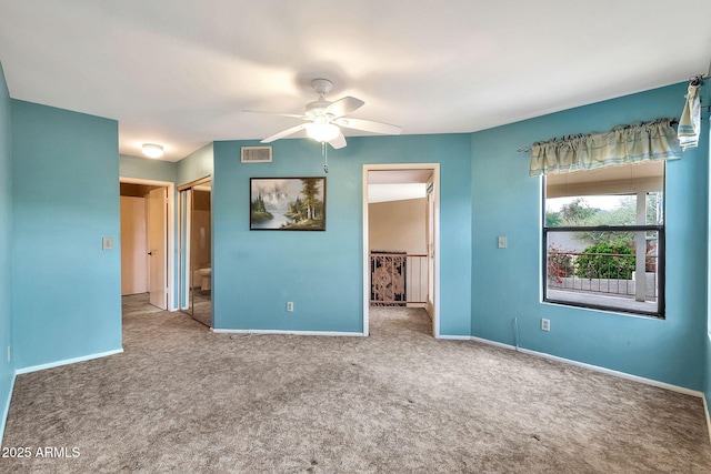 empty room featuring visible vents, a ceiling fan, baseboards, and carpet floors