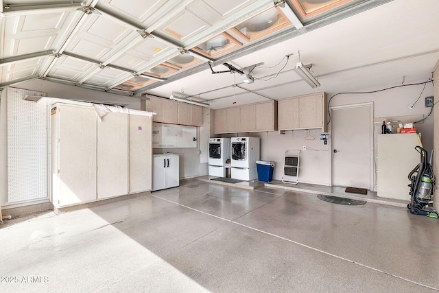 garage featuring heating unit and separate washer and dryer