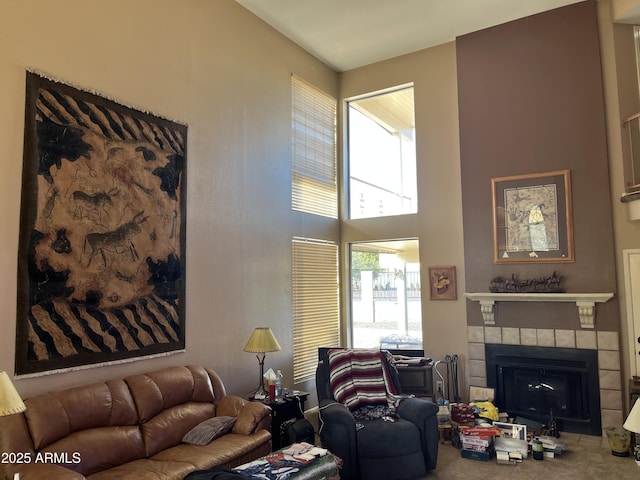 carpeted living area with a high ceiling and a fireplace