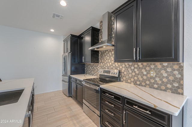 kitchen with sink, wall chimney range hood, light stone counters, electric stove, and decorative backsplash