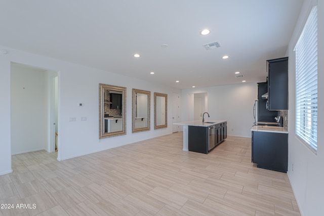 kitchen featuring a kitchen island with sink and sink