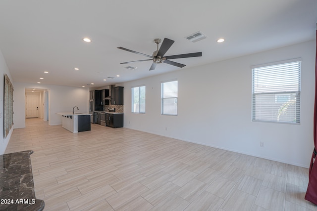 unfurnished living room with light hardwood / wood-style flooring and ceiling fan