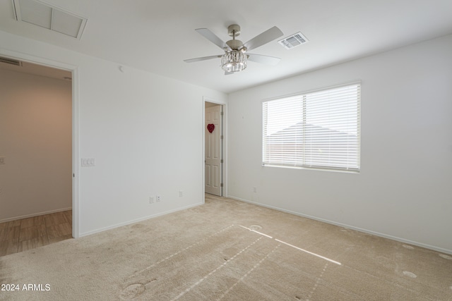 spare room with light carpet and ceiling fan