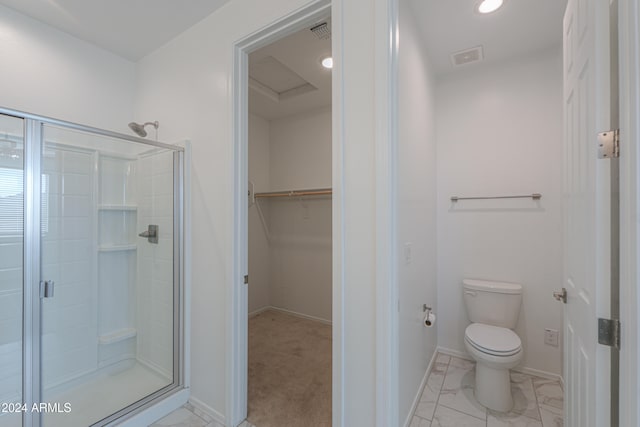 bathroom with toilet and a shower with door