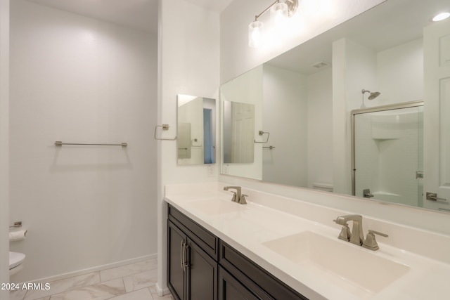 bathroom with vanity, toilet, and a shower with door