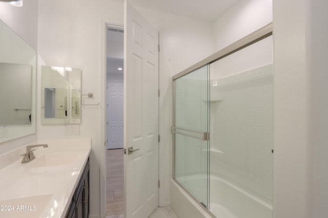 bathroom with shower / bath combination with glass door, wood-type flooring, and vanity