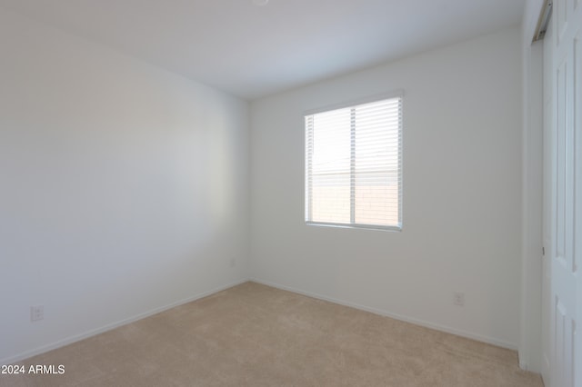 unfurnished room featuring light carpet