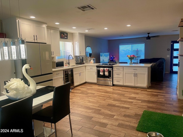 kitchen featuring stainless steel appliances, ceiling fan, white cabinets, light hardwood / wood-style floors, and wine cooler