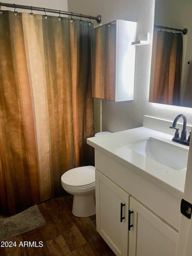 bathroom featuring hardwood / wood-style floors, vanity, and toilet