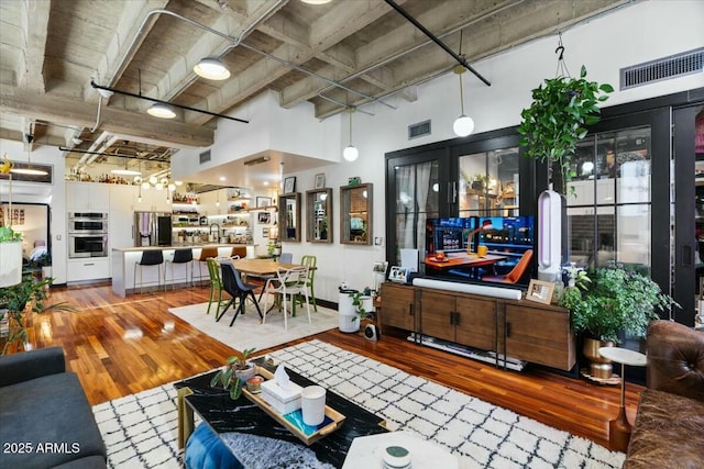 living room featuring wood-type flooring and a high ceiling