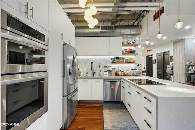 kitchen featuring hanging light fixtures, dark hardwood / wood-style flooring, white cabinets, tasteful backsplash, and stainless steel appliances