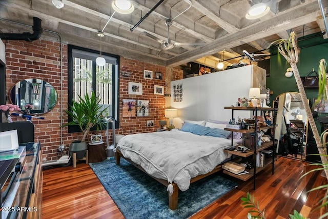 bedroom with hardwood / wood-style floors, brick wall, and ceiling fan