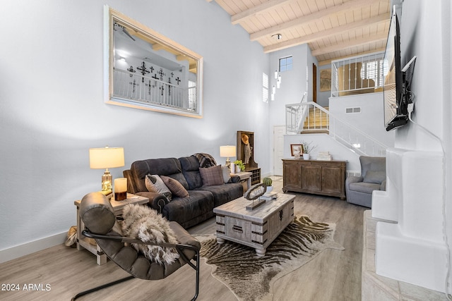 living room with beam ceiling, light hardwood / wood-style floors, and wood ceiling