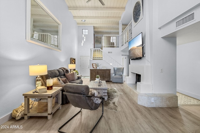 living room featuring a wealth of natural light, beamed ceiling, wooden ceiling, and ceiling fan