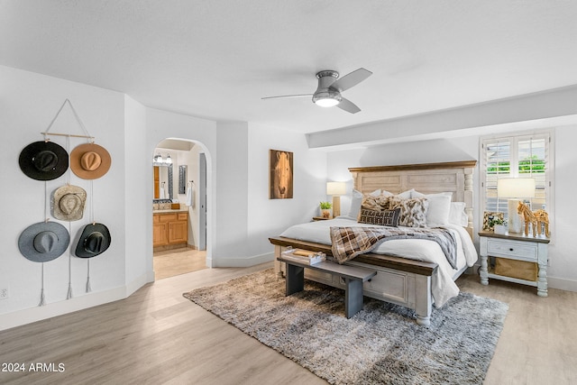 bedroom with light wood-type flooring, connected bathroom, and ceiling fan