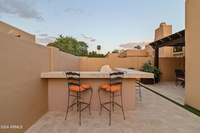 patio terrace at dusk featuring an outdoor bar