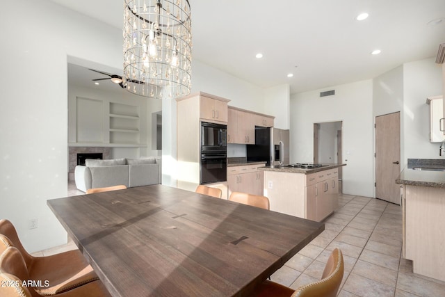 tiled dining room featuring ceiling fan with notable chandelier and sink