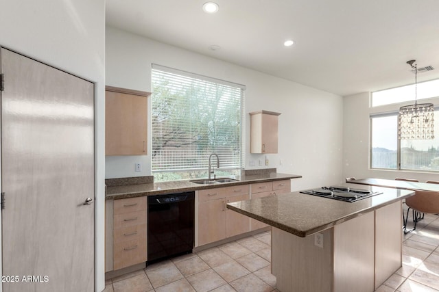 kitchen with pendant lighting, dishwasher, sink, light brown cabinetry, and cooktop