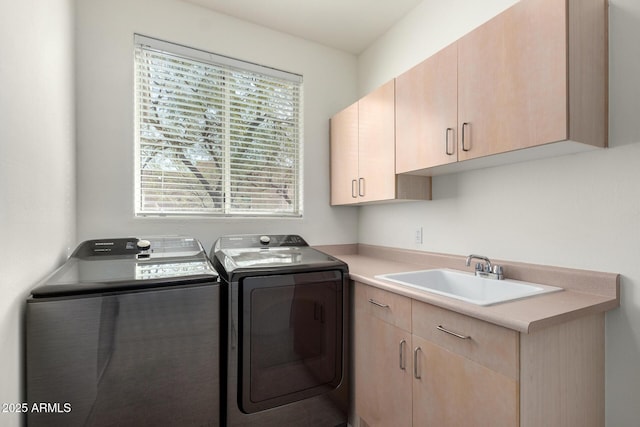 washroom with washer and clothes dryer, cabinets, and sink