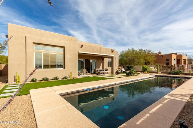 back of house featuring a patio area and a fenced in pool