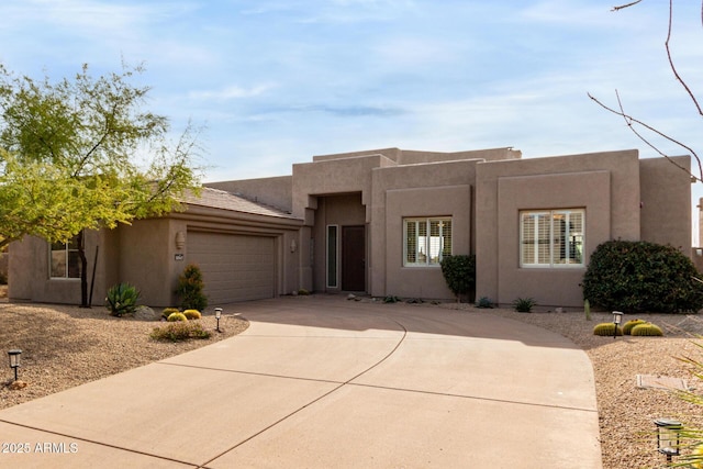 pueblo revival-style home featuring a garage