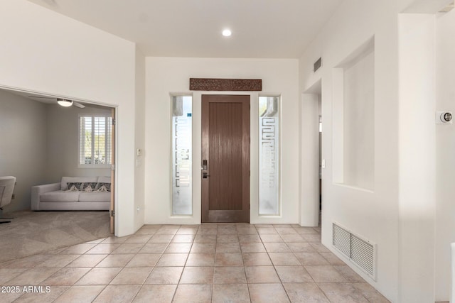 foyer with ceiling fan and light tile patterned flooring