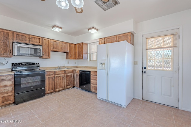 kitchen featuring ceiling fan, sink, light tile patterned floors, and black appliances