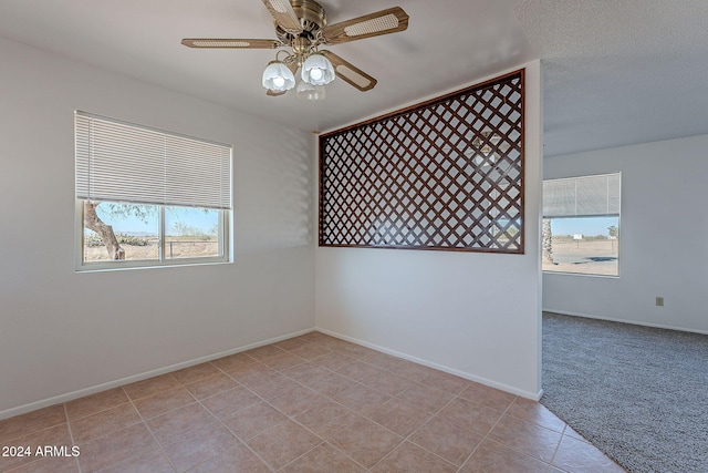 tiled empty room featuring a textured ceiling and ceiling fan