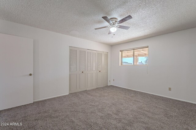 unfurnished bedroom with ceiling fan, carpet floors, a textured ceiling, and a closet