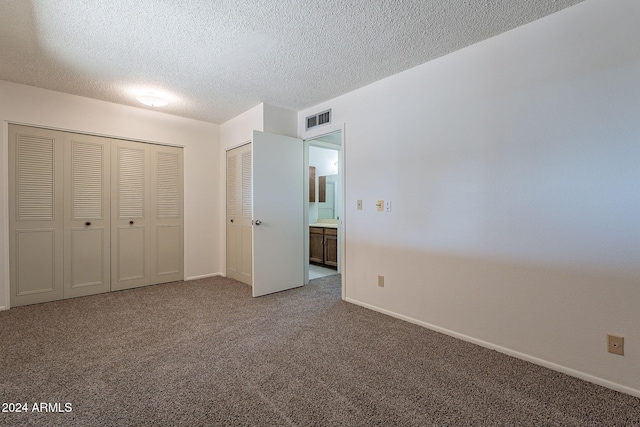 unfurnished bedroom featuring carpet and a textured ceiling