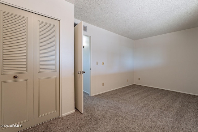 unfurnished bedroom with carpet flooring, a closet, and a textured ceiling