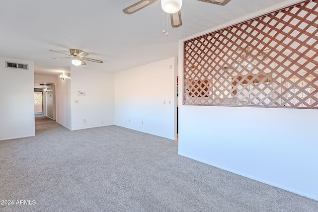 carpeted empty room featuring ceiling fan and a textured ceiling