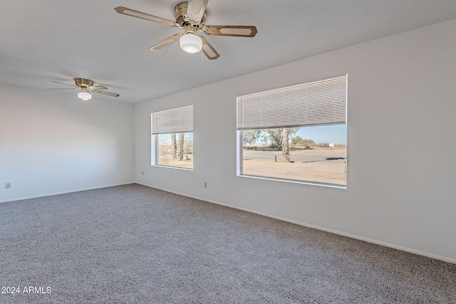 carpeted spare room with ceiling fan and a textured ceiling