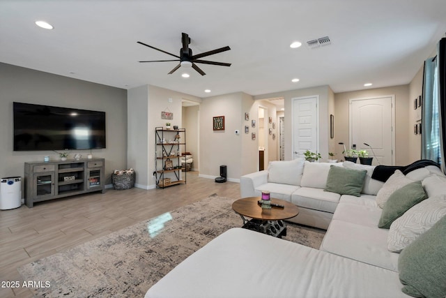 living room with ceiling fan and light hardwood / wood-style flooring