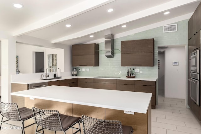 kitchen with modern cabinets, a breakfast bar area, a sink, and stainless steel appliances