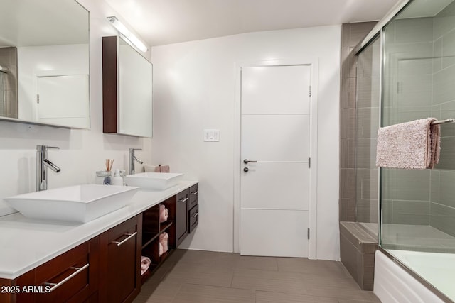 full bath featuring double vanity, a sink, a tub to relax in, and an enclosed shower