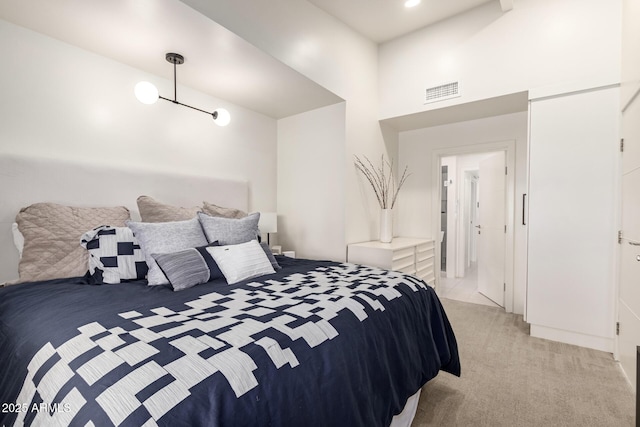 bedroom featuring a high ceiling, visible vents, and light colored carpet