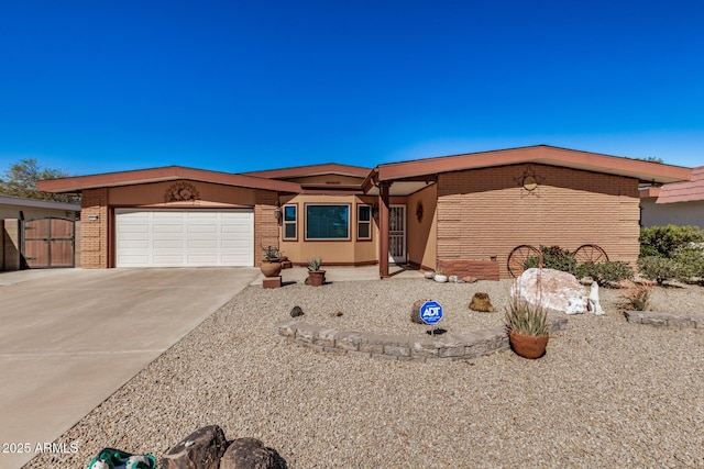 view of front facade featuring an attached garage, concrete driveway, and brick siding