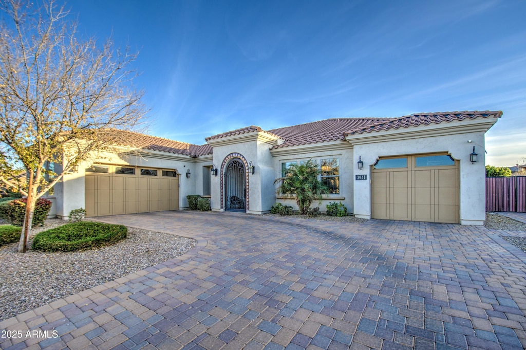 mediterranean / spanish home with a garage