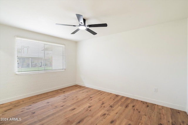 empty room featuring hardwood / wood-style floors and brick wall