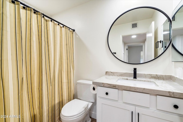 bathroom with vanity, toilet, and curtained shower