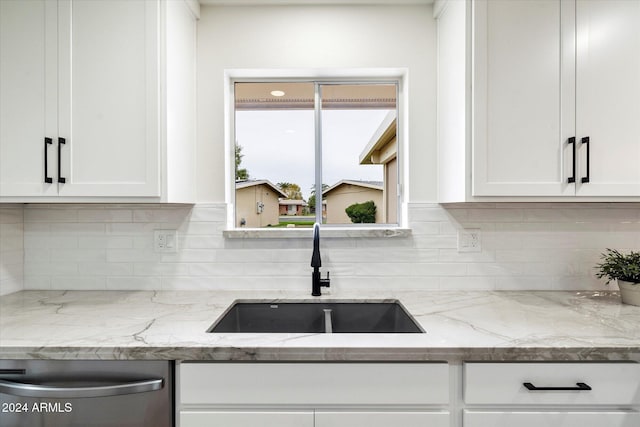 kitchen featuring light stone countertops, decorative backsplash, sink, dishwasher, and white cabinets