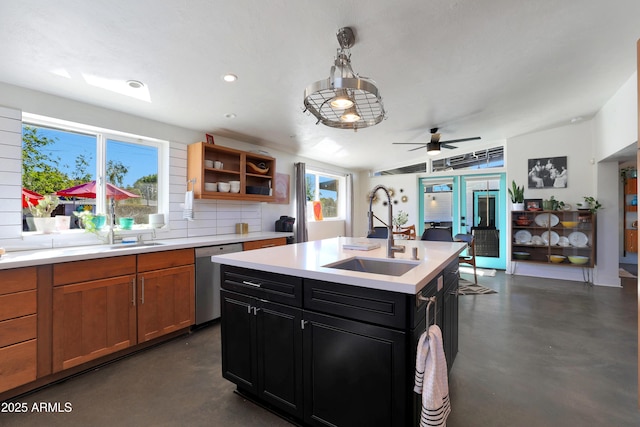 kitchen featuring dishwasher, sink, pendant lighting, backsplash, and an island with sink