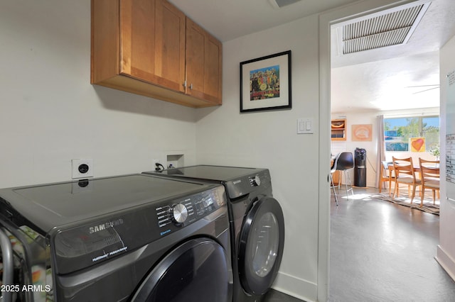 laundry room featuring cabinets and washer and clothes dryer