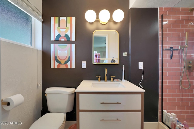 bathroom featuring vanity, toilet, and tiled shower